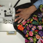 Manos trabajan un bordado floral del Taller Biulú fundado por Elvis Guerra