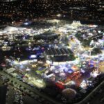 Vista aérea nocturna del recinto de la Feria Tamaulipas con juegos y espacios comerciales
