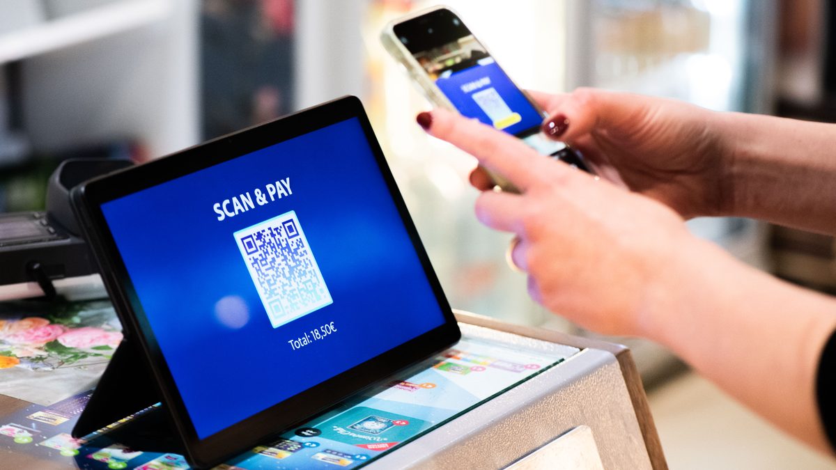 Persona realiza un pago digital con código QR desde un teléfono móvil