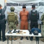 Elemento de seguridad federal custodia a una persona detenida durante un operativo en Sinaloa