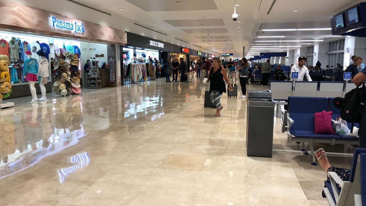 Sala de embarque con viajeros en la Terminal 4 del Aeropuerto Internacional de Cancún