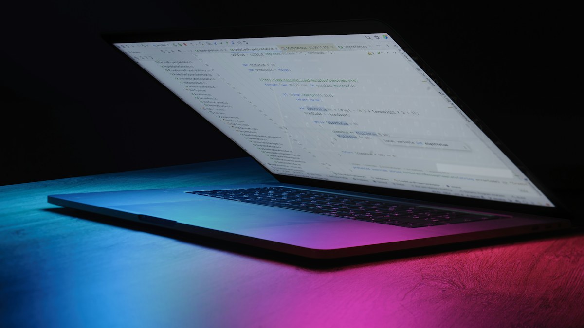 Computadora portátil con código en pantalla en un entorno de trabajo tecnológico