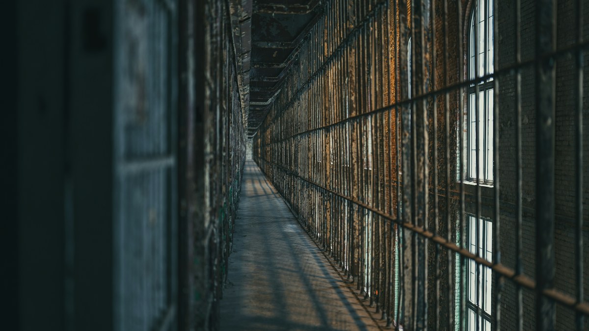 Corredor penitenciario con celdas y barrotes