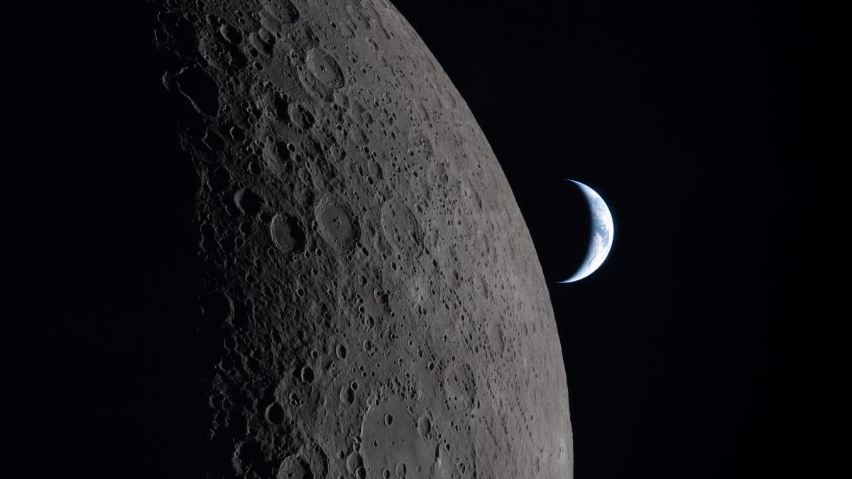 La Luna en primer plano y la Tierra al fondo durante la misión Artemis I