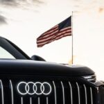 Vehículo Audi frente a una bandera de Estados Unidos, imagen oficial del proyecto de planta en Georgia