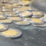 Monedas mexicanas sobre una superficie metálica, imagen sobre deuda y finanzas públicas