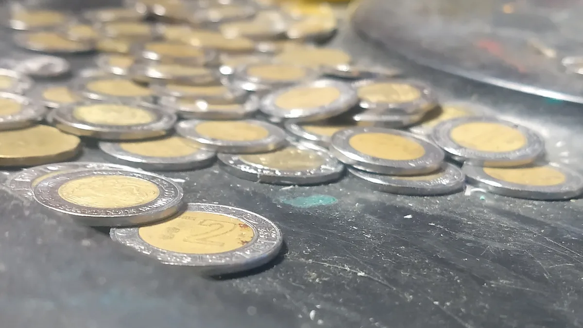 Monedas mexicanas sobre una superficie metálica, imagen sobre deuda y finanzas públicas