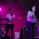 Carla Morrison canta en un escenario durante un concierto al aire libre
