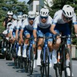 Ciclistas juveniles del equipo A.R. Monex entrenan en formación sobre una carretera