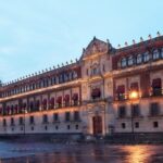Fachada iluminada de Palacio Nacional en Ciudad de México después de la lluvia, fotografía de archivo
