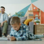 Niño utiliza un teléfono inteligente bajo supervisión de sus padres