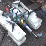 Dron FPV con hélices y equipo de control en un campo
