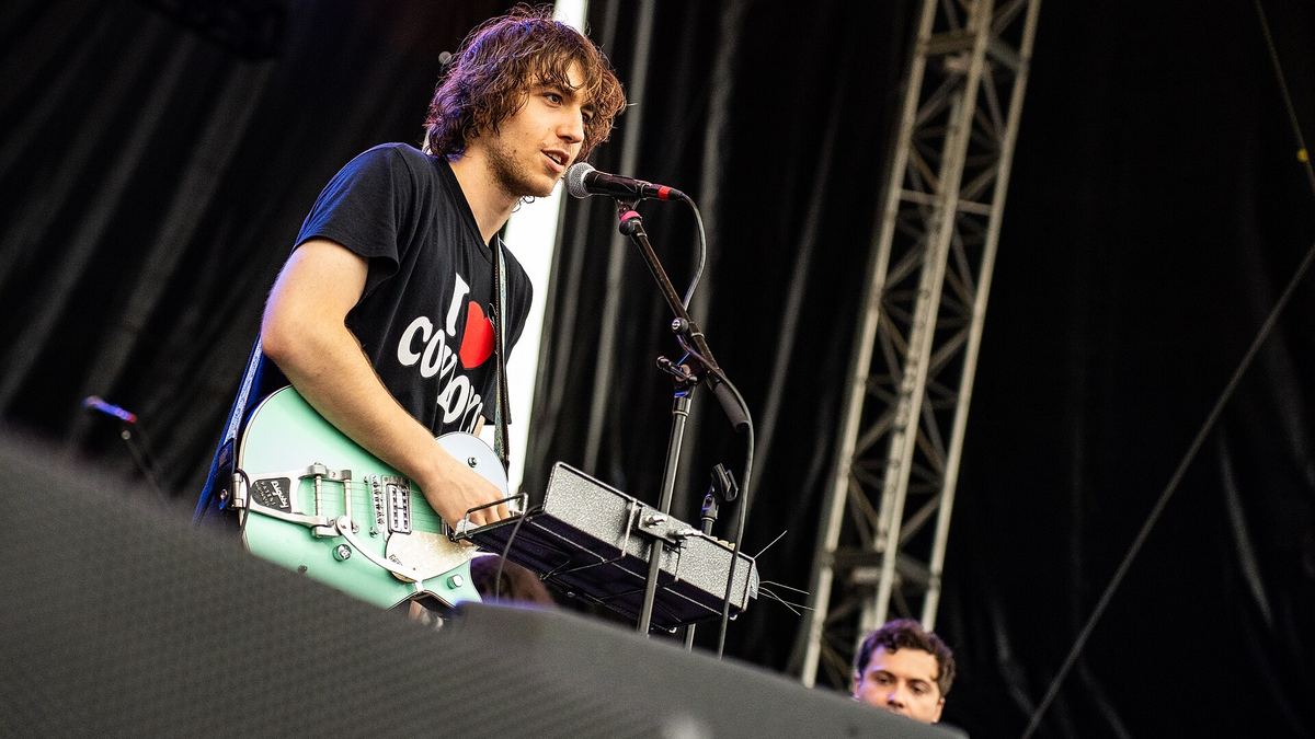 Cameron Winter, vocalista de Geese, toca guitarra y canta en un escenario