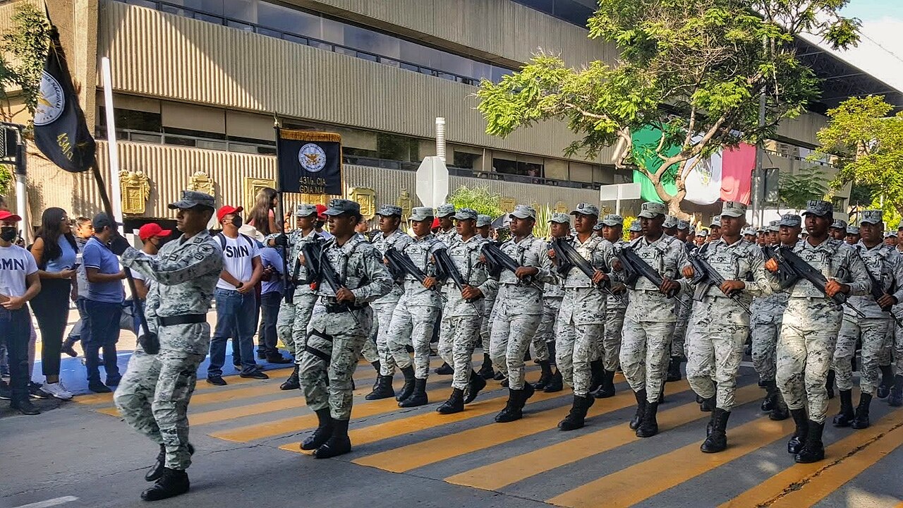 Elementos de la Guardia Nacional marchan en formación durante un desfile en Tijuana