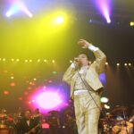 Juan Gabriel canta en un escenario durante un concierto acompañado por músicos
