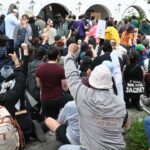 Manifestantes arrodillados frente a policías durante la protesta por agua limpia en Guadalajara