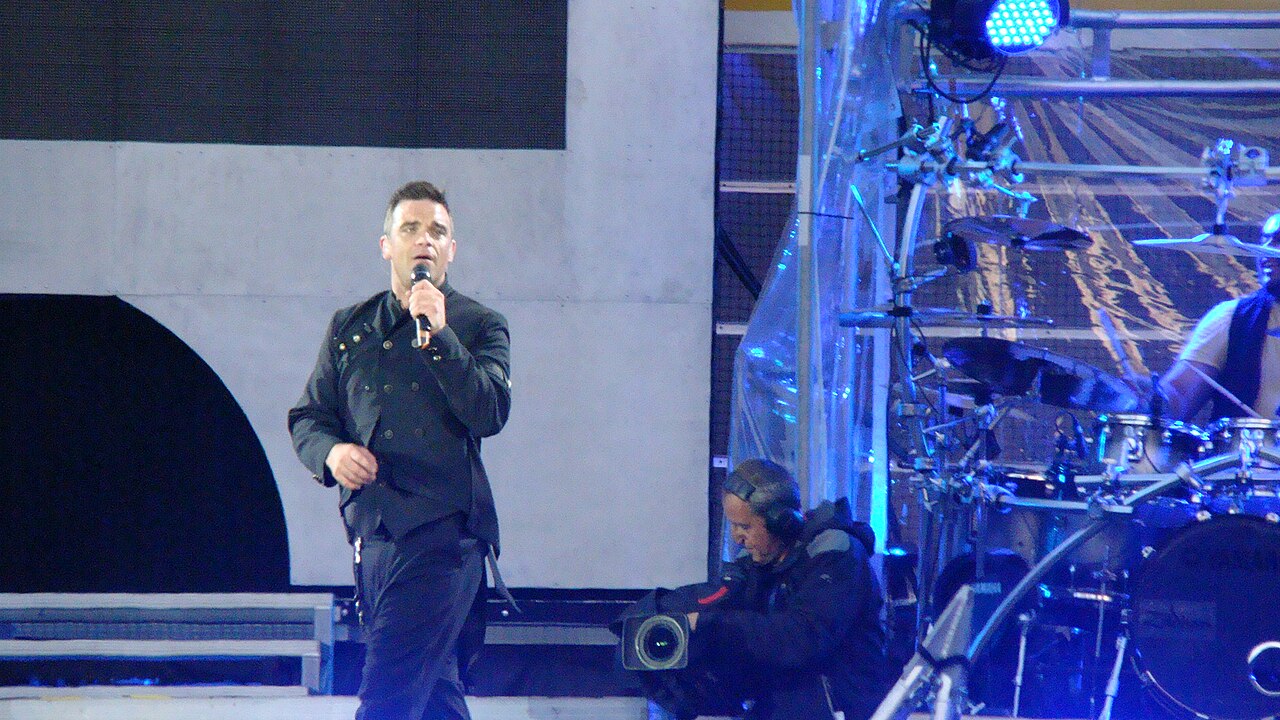 Robbie Williams canta en un escenario durante un concierto