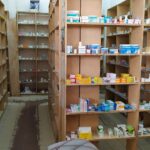 Estantes de farmacia con medicamentos e insumos organizados