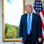 Donald Trump de pie ante banderas de Estados Unidos en la Casa Blanca