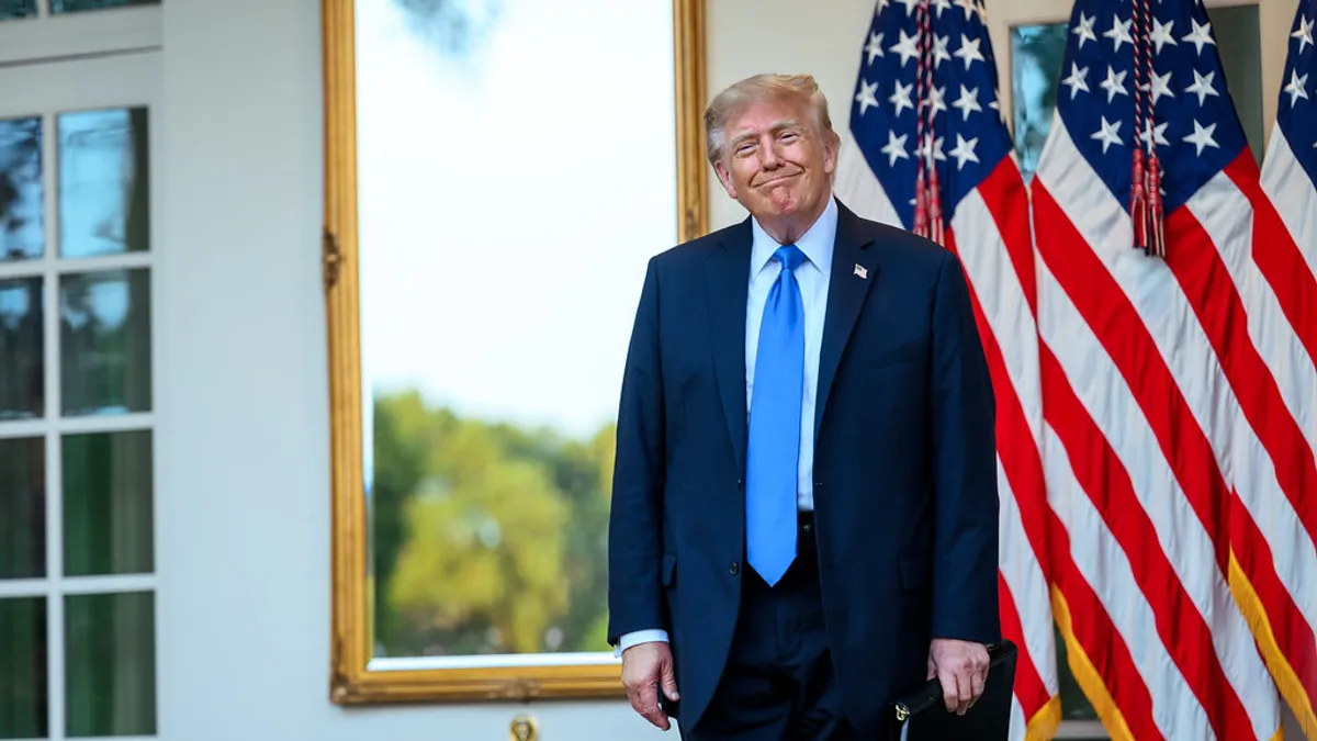 Donald Trump de pie ante banderas de Estados Unidos en la Casa Blanca