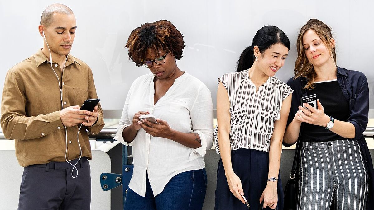 Grupo de jóvenes utiliza teléfonos móviles en un entorno urbano